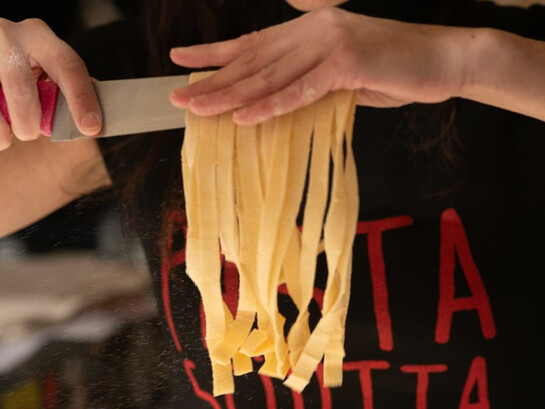 La résistance se savoure : dans La Pastasciutta antifascista, chaque geste compte. Ici, les bras d’une interprète révèlent les spaghettis fraîchement coupés, symbole d’un acte quotidien devenu acte de liberté et de partage