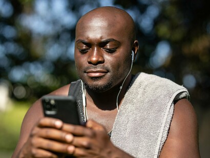 A man using his mobile phone outdoors, representing the everyday accessibility of mobile money in Kenya