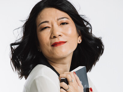 Une femme, livre contre le cœur, incarne la fragilité et la force des émotions humaines au centre de cette histoire intime.  
Photo par Aura Constantin