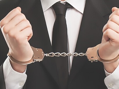 A photograph depicting a man wearing handcuffs, evoking themes of criminal justice and prison reform