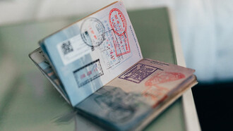 A collection of visas adorning the pages of a passport like colorful stamps from around the world
