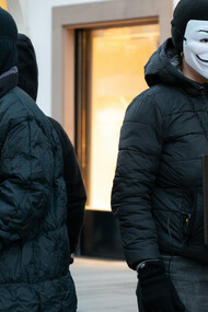 Masked figures holding placards to demand the truth