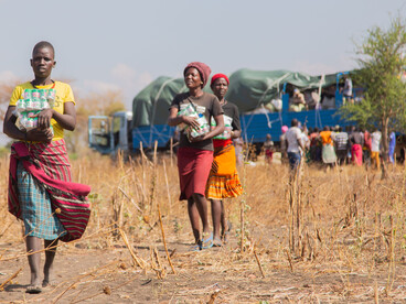 People receive humanitarian aid in a rural area of Sudan during the day