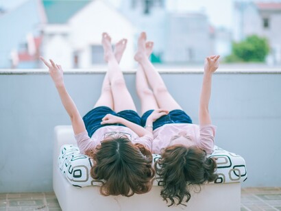 Two friends laying together on a seat 