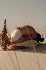 A shared reverence, Karlien folding into the dunes beside ‘Diatom Bokeh’ from the Epiphanic series collaboration with Reticence Studio, photographed by Driaan Claassen