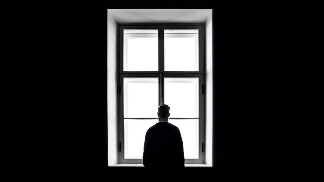 Hombre solitario mira por la ventana