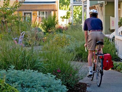 A mailman on his bike delivering good news to the members of the cohousing community