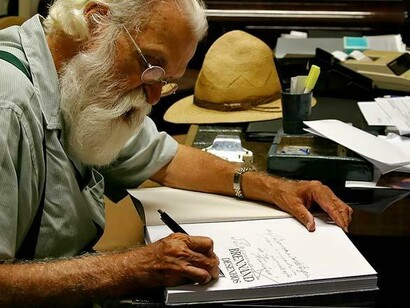 Imagem do artista autografando um de seus livros. © Oficina Brennand