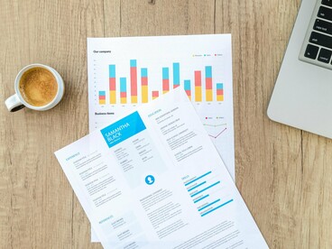 A resume on a desk beside performance metrics, representing the transformation of recruitment into a data-centric process