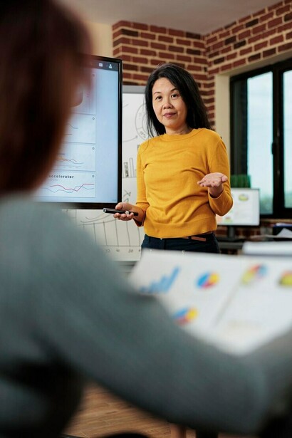 Executive manager with clipboard outlining marketing statistics and strategic plans to boost revenue in a startup office meeting