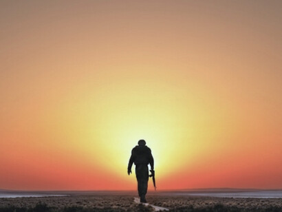 The silhouetted figure represents the normalization of militarization that Ramparts Magazine consistently denounced