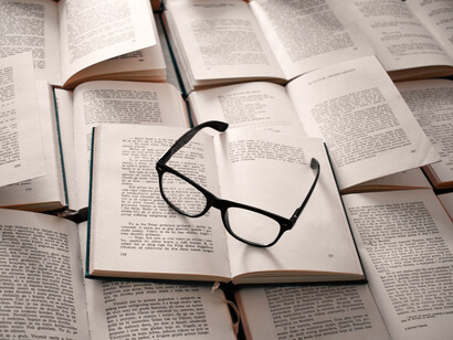 Monturas de gafas encima de varios libros abiertos