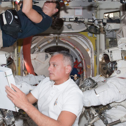 A view of astronauts Danny Olivas and Nicole Stott conducting Extravehicular Mobility Unit (EMU) preparations in the joint airlock during the STS-128 mission