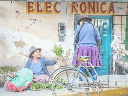 An old woman gifting free food to someone of her species who doesn't seem in need
