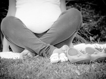 Una mujer embarazada sentada en el césped. Fotografía Rebeca Rodríguez Elías, 2013       