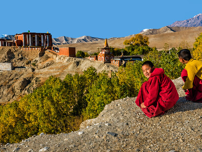 A novice Tibetan monk stands near Tsarang Village, taking in the vast and remote landscapes of Upper Mustang, Nepal