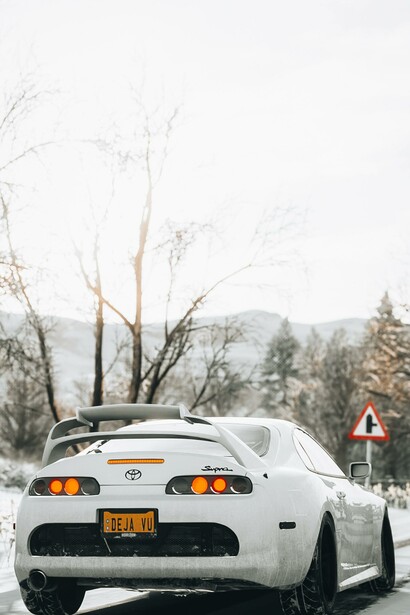 A white car on a road in a snowy place