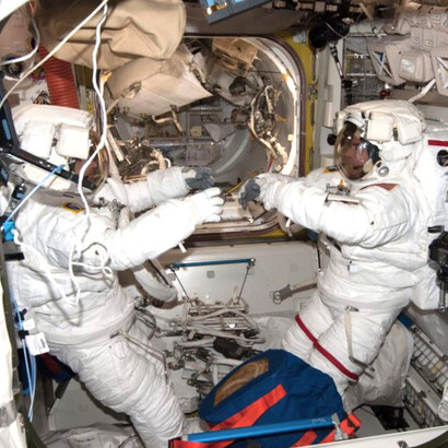 ISS036-E-017415 (8 July 2013) — NASA astronaut Chris Cassidy (right) and ESA astronaut Luca Parmitano, both Expedition 36 flight engineers, are seen inside the Quest airlock of the International Space Station as they prepare for an extravehicular activity (EVA). The two astronauts are suited up in their Extravehicular Mobility Unit (EMU) spacesuits
