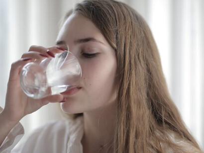 A woman is seen hydrating herself by drinking water