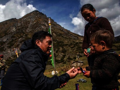 Pema Khandu with children in the Indian mountains. Post his father's death, Khandu was included in the state government as Cabinet Minister for Water Resource Development and Tourism, India