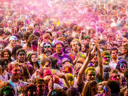 A sea of festival-goers converges in a vast crowd, embodying the herd mentality that drives people to follow trends without questioning their logic or relevance