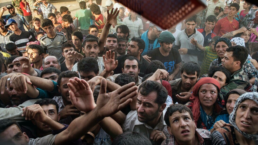 Syrian refugees fight for clothes and other items being distributed by Kurdish people at the Kawrkos camp outside of Erbil, in Northern Iraq, August 20, 2013 captured by Lynsey Addario