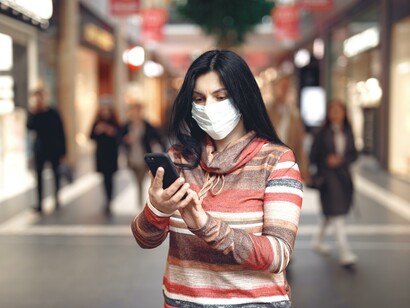 Mulher de máscara usando o celular