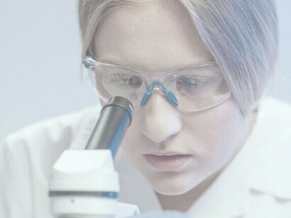 Una científica que realiza investigaciones meticulosamente, utilizando un microscopio en el ambiente controlado de un laboratorio