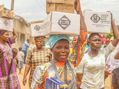 Women carrying cardboard boxes on their heads queue for food aid during the hunger crisis in Lagos, Nigeria