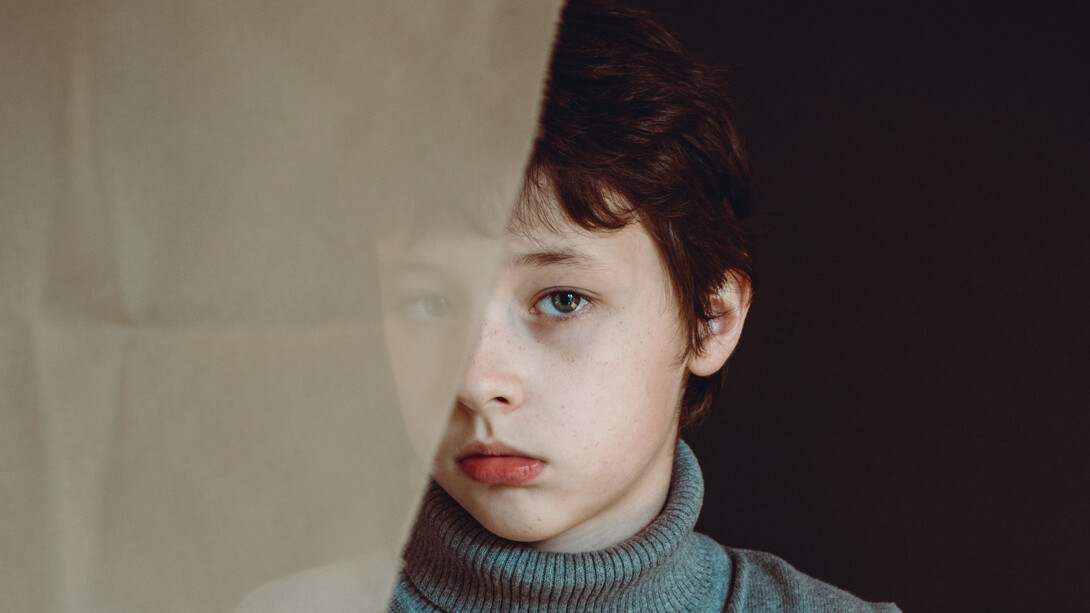 Menino olha fixamente para o nada enquanto viajava nos cenários criados em sua mente