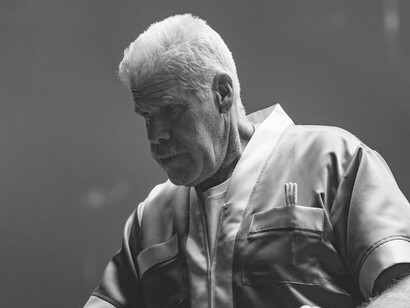 In the intensity of the final match, Stevie, portrayed by Ron Perlman, stands stoically in the corner of the ring, his unwavering focus a reflection of the deep bond he shares with Flannigan as both trainer and mentor