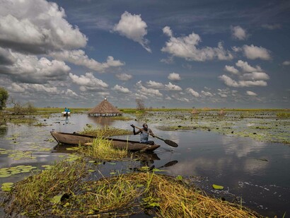A man rows through what was once dry land in the village of Patiou in Twic East County, Jonglei State, South Sudan, October 22, 2021 captured by Lynsey Addario