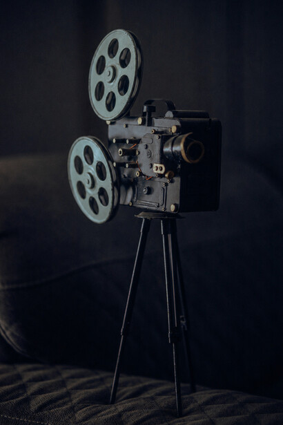 A câmera vintage simboliza um tempo em que os filmes eram construídos com maquetes, luzes reais e efeitos práticos. O artigo defende justamente essa herança artesanal do cinema que ainda emociona espectadores décadas depois. Em meio a engrenagens e película, sobrevive a memória de um cinema mais físico, humano e autoral