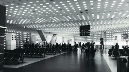 Área de embarque em aeroporto. Depois de muitos agradecimentos e ajustadas as fichas de embarque, o sujeito seguiu sorridente para o portão de embarque, olhos brilhando, feliz por ter conseguido aquilo que queria e agradecido ao meu colega pela gentileza. Conseguiu sua mamadeira...