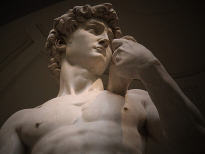 A low-angle view of Michelangelo’s David at the Accademia Gallery in Florence, Italy