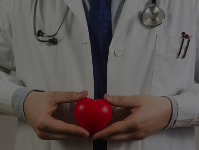 A doctor holding a plastic heart, symbolizing the connection between cardiovascular health, positive thinking, and mental well-being