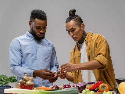 Two people using fresh vegetables side by side, reflecting the idea that wellbeing is built through everyday choices and meaningful connections