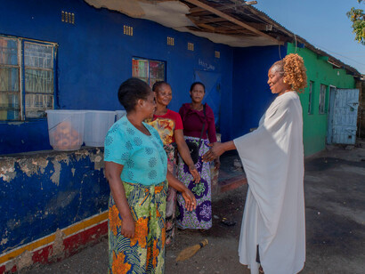 As they shake hands, the bond between the local leader and the women symbolises the importance of grassroots unity in the face of global crises