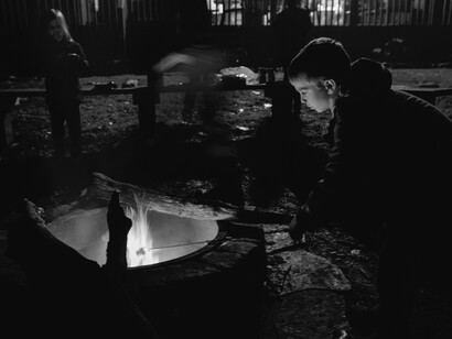 Un niño absorto por la luz del fuego en mitad de la noche