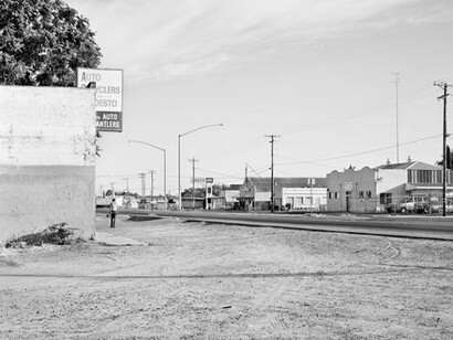 Katy Grannan, Man walks alone through empty lot, intersection of South 9th Street and River Road, Modesto, CA, 2014