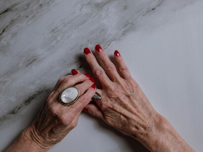 Aged hands of an older woman with rings on her fingers