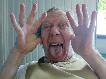 Uomo che fa una pernacchia usando mani e lingua