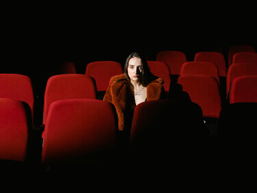 A woman watching a performance from her theater seat
