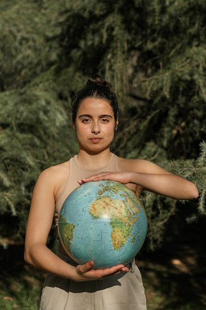 With a gentle touch, the woman holds the Earth globe, embodying her connection and responsibility