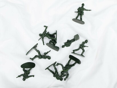 Scattered toy soldiers lying across a white surface, representing the lasting human cost of war and the memories that continue to shape Germany's policies