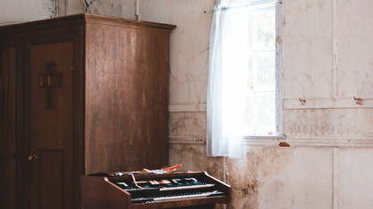 Cômodo vazio de uma casa e a vento que entra pela janela quebrada preenche o ambiente