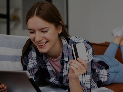 In the era of pandemic-driven digitalization, a woman embraces online shopping, browsing her tablet while holding a credit card, showcasing the widespread adoption of e-commerce during COVID-19