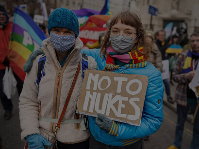 A photo capturing two women at a pro-Ukraine protest in Trafalgar Square, London, UK, holding a banner that reads: "No to Nukes"