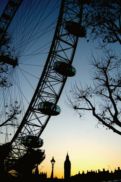 At night, the London Eye in London, UK, lights up in dazzling colors