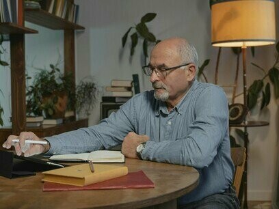 Homem escreve em seu caderno. Passava horas nos cafés e esplanadas a ouvir conversas para criar personagens, mas depois dispersava-se com questões como o tipo de caneta a usar, se uma Rotring de ponta 0,1 ou uma caneta de tinta permanente para tomar as suas notas. A obsessão era uma forma de adiar. A escrita uma maneira de viver